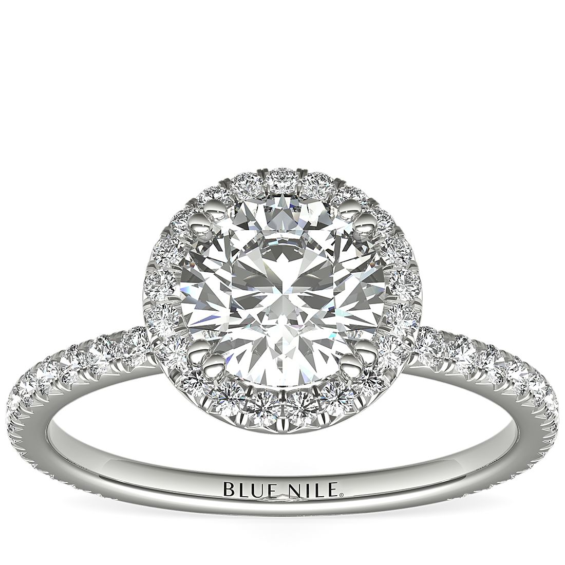 An engagement ring with a 1-carat round center diamond surrounded by french pavé set diamonds.